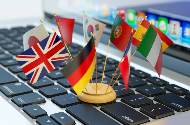 Tischflaggen auf einer Laptop-Tastatur - Übersetzungen in viele Sprachen