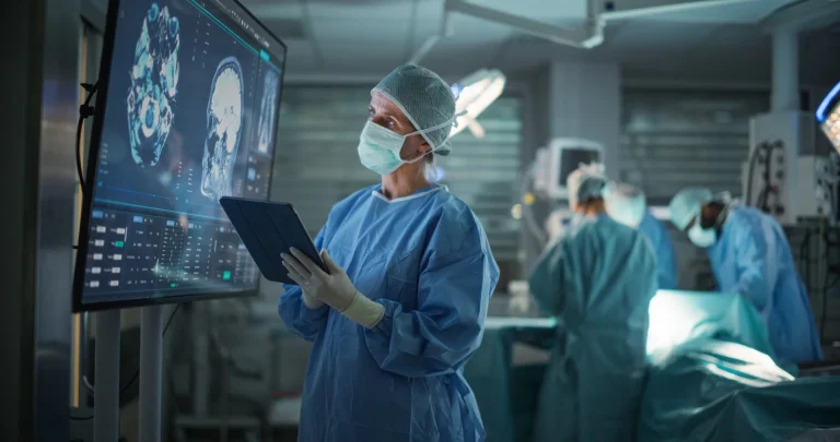 Operationsteam im Operationssaal, davor ein Monitor mit MRT-Aufnahmen und ein Tablet - technische Übersetzungen für die Medizintechnik