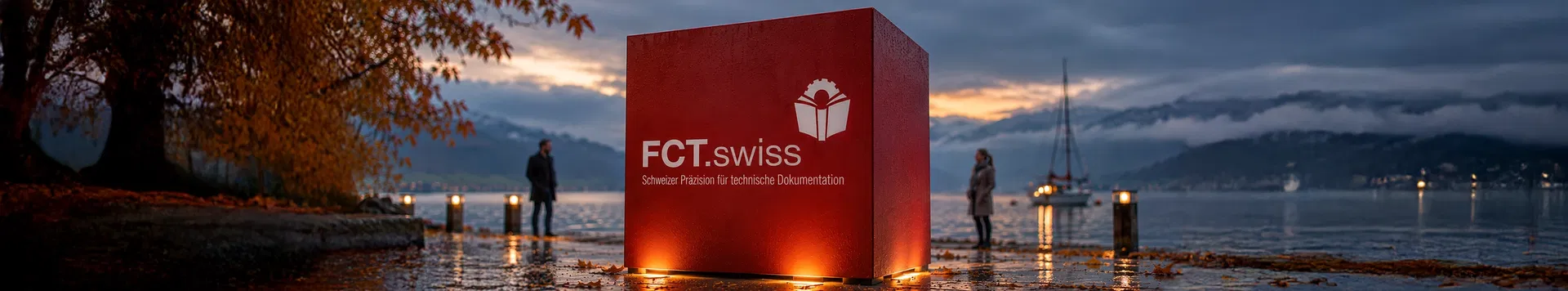 Roter Würfel mit dem Logo von FCT.swiss am Seeufer in der Dämmerung