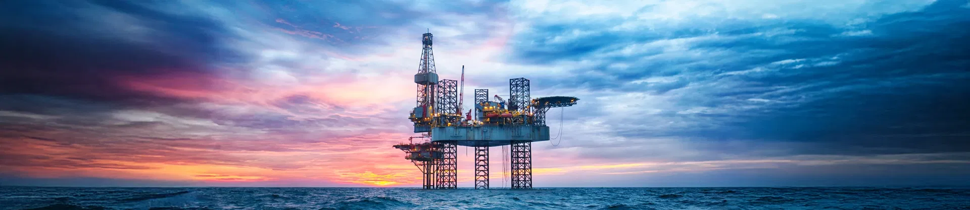 Bohrinsel auf dem offenen Meer in der Abenddämmerung